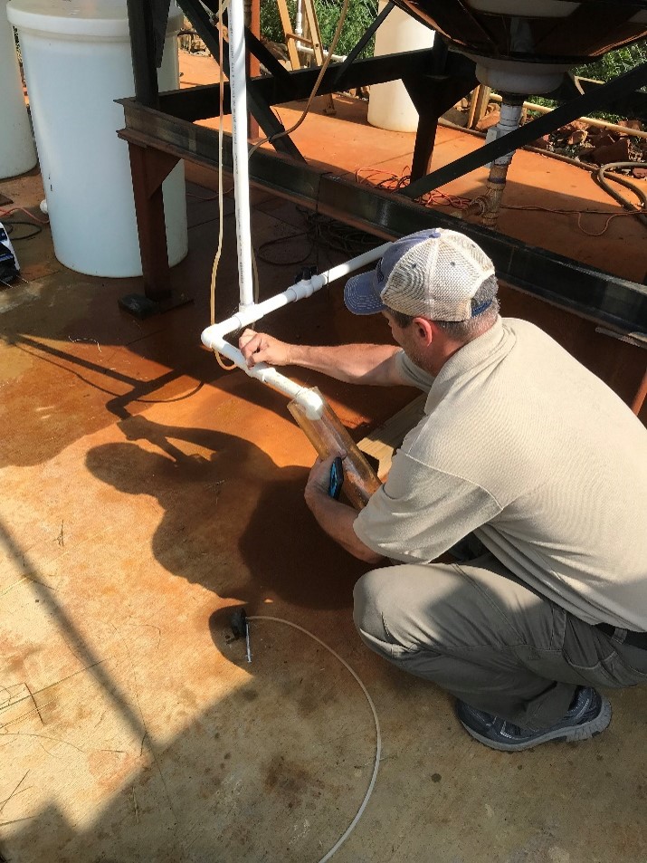 OSMRE hydrologist Brent Means sampling water at the Truetown site. Photo courtesy of Kaabe Shaw.