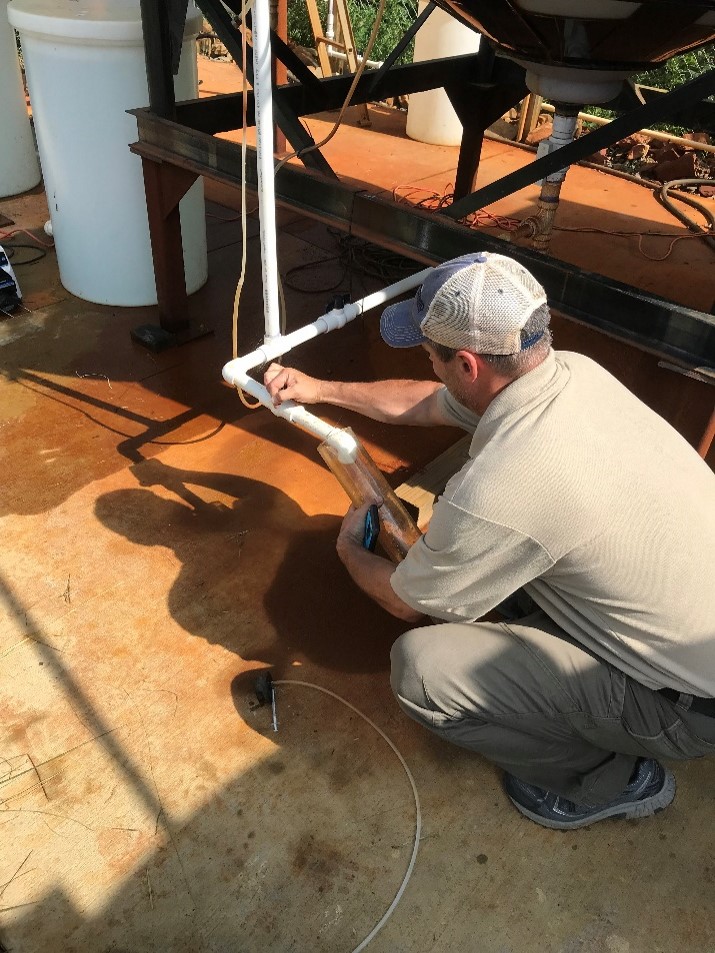 OSMRE hydrologist Brent Means sampling water at the Truetown site.  Photo courtesy of Kaabe Shaw.