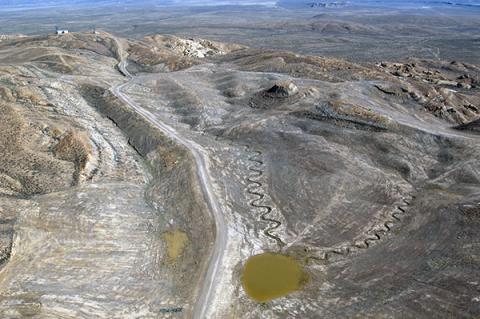 Aerial image showing AML reclamation project in Sweetwater, Wyoming. Gray and brown scenery shows improved walls, channels, and access roads across gentle hills.